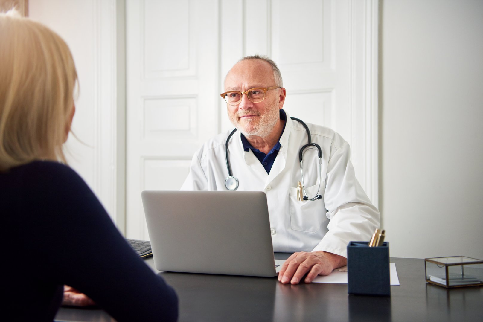 therapist-listening-to-patient-at-laptop-in-hospit-W5QTGJ4